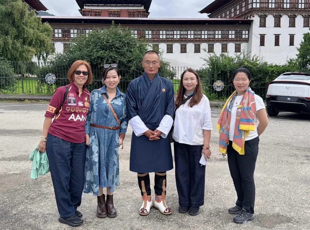 Guests standing together in front of Bhutanese architecture