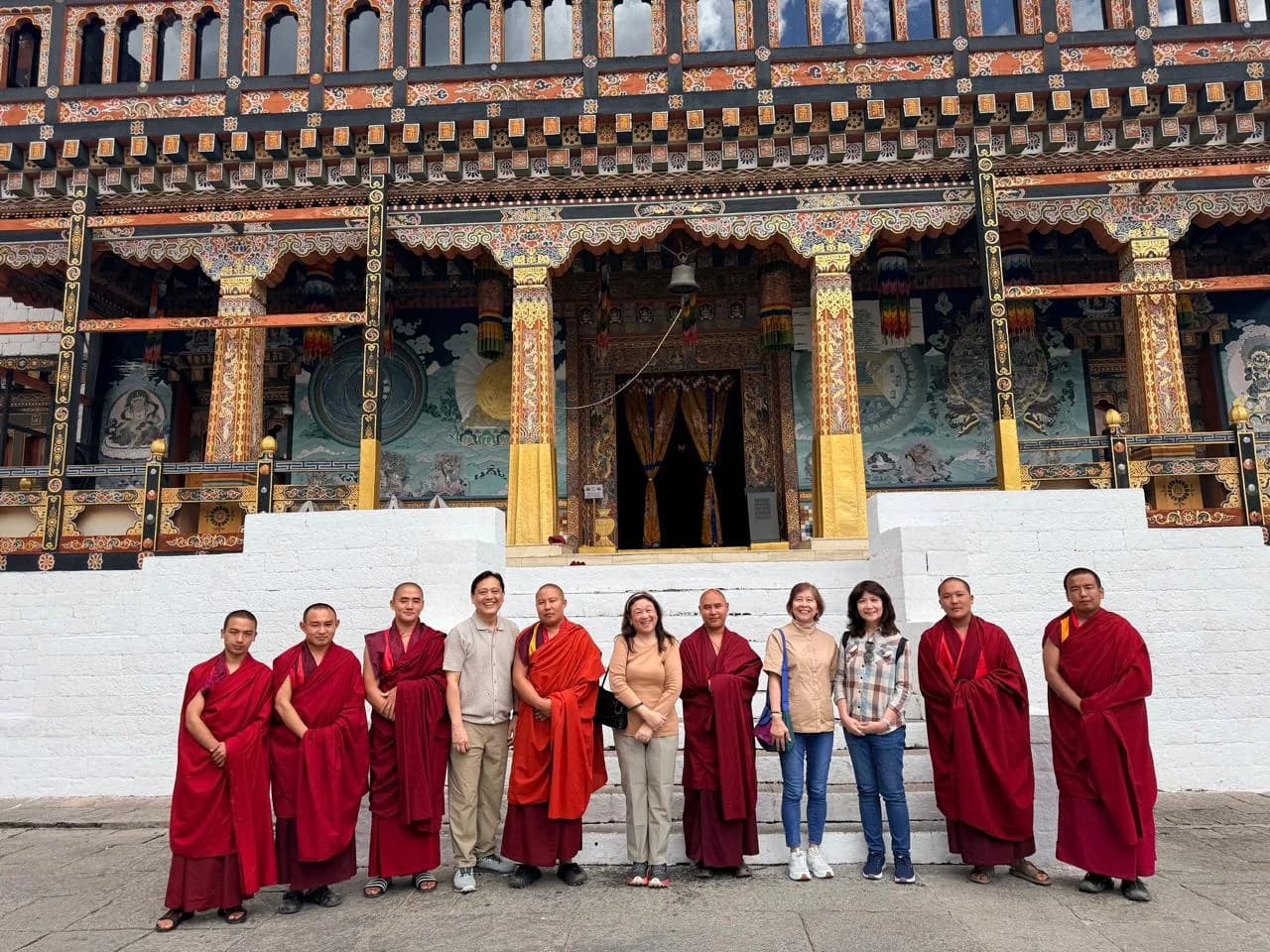 Guests with monks in the courtyard of a Bhutanese monastery