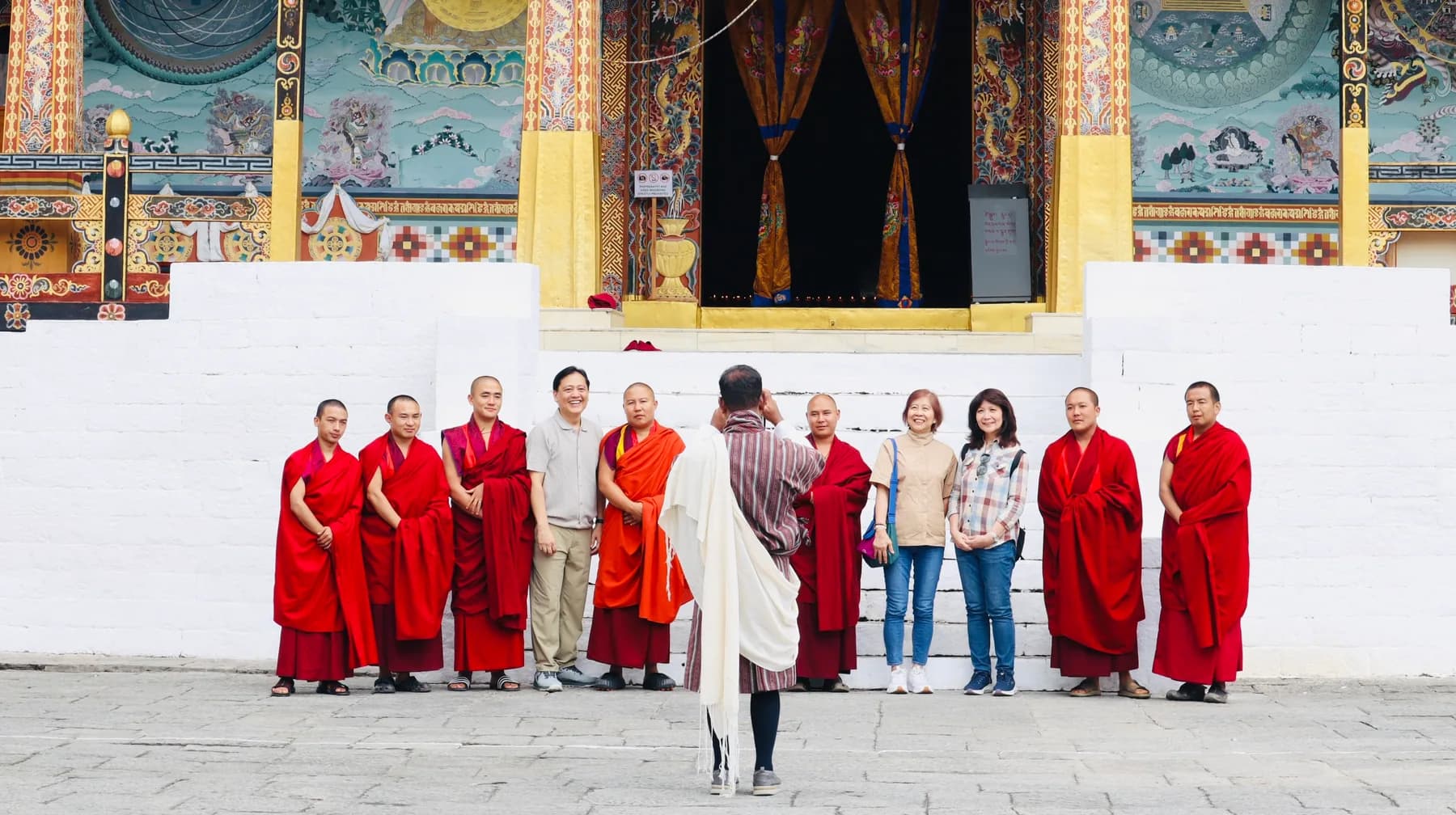 Guests and monks standing together at a monastery